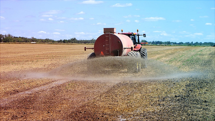 Trecker auf Feld versprüht Düngemittel