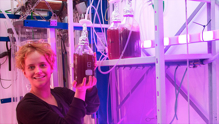 elisa schaum mit einer Behältniss mit roter Flüssigkeit in der Hand