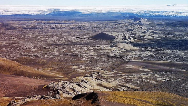 weite Fläche, Hügellandschaft, Vegetationsllos, schneebedeckte Berge in Hintergrund
